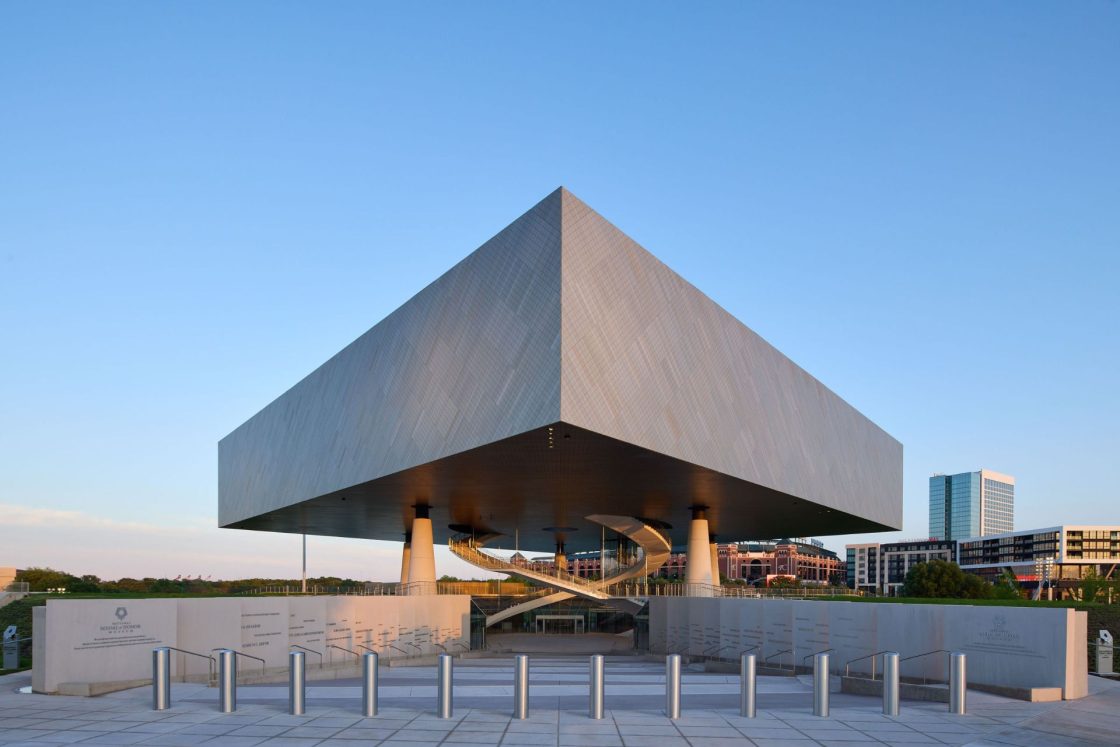 Fachada de museu com pilotis, escadas em formato orgânico e volume amplo e quadrado sobre colunas