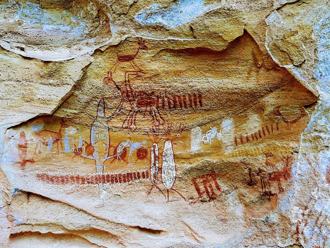 Painel de pinturas rupestres preservado no Parque Nacional da Serra da Capivara, com figuras humanas, animais e formas geométricas registradas sobre a superfície rochosa